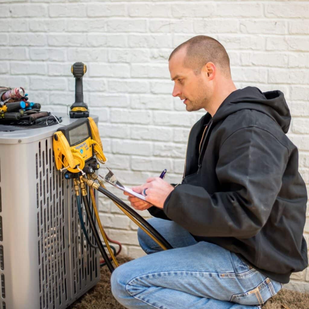 HVAC Technician working on a AC unit on the exterior of a home