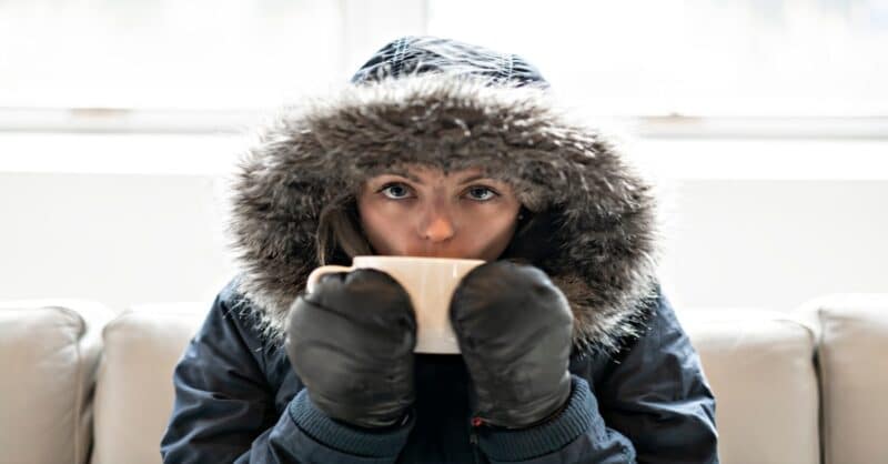 woman that is trying to stay warm in her home